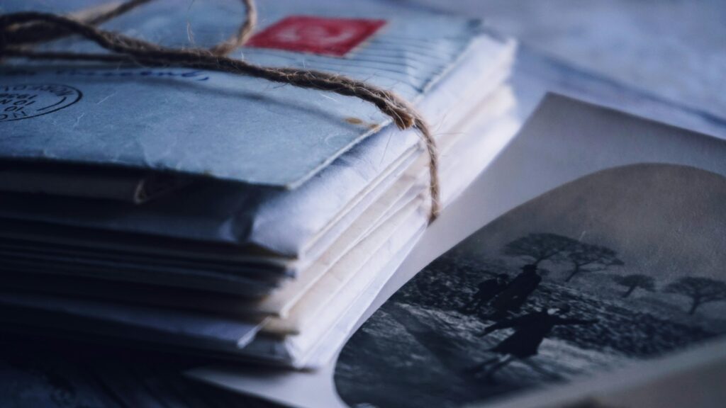 A close-up of vintage letters tied with twine alongside an old black and white photograph.