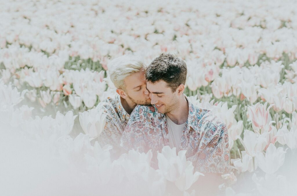 A joyful couple sharing a tender moment in a sunlit tulip field.