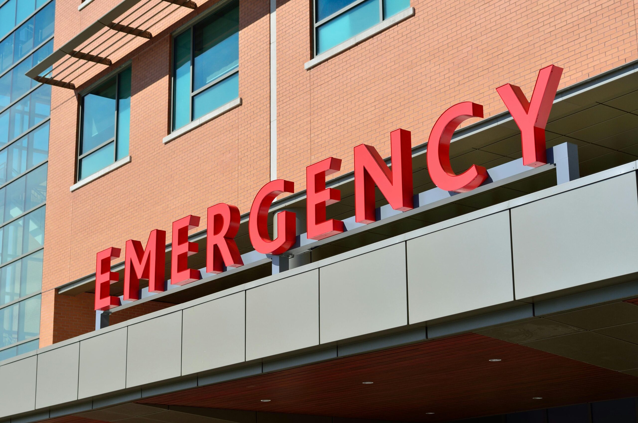 Close-up of a modern hospital emergency room entrance with prominent red letters.