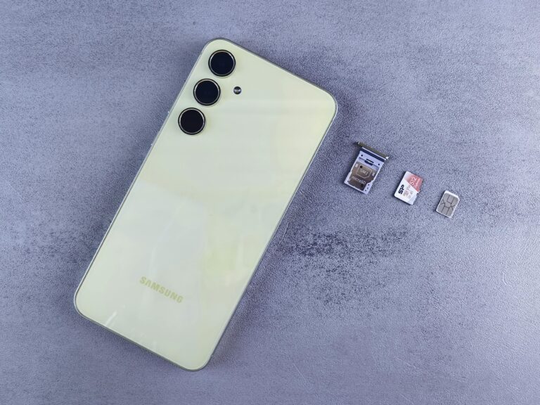 Yellow smartphone with SIM tray, memory card, and SIM card on gray background.