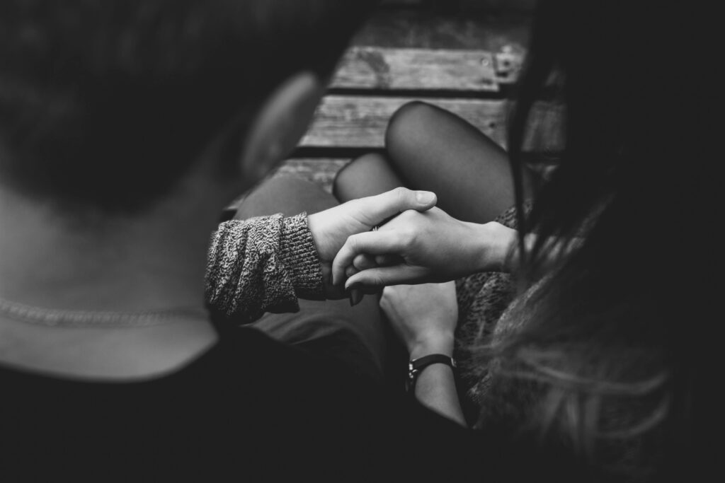 A romantic black and white image of a couple holding hands, symbolizing love and connection.