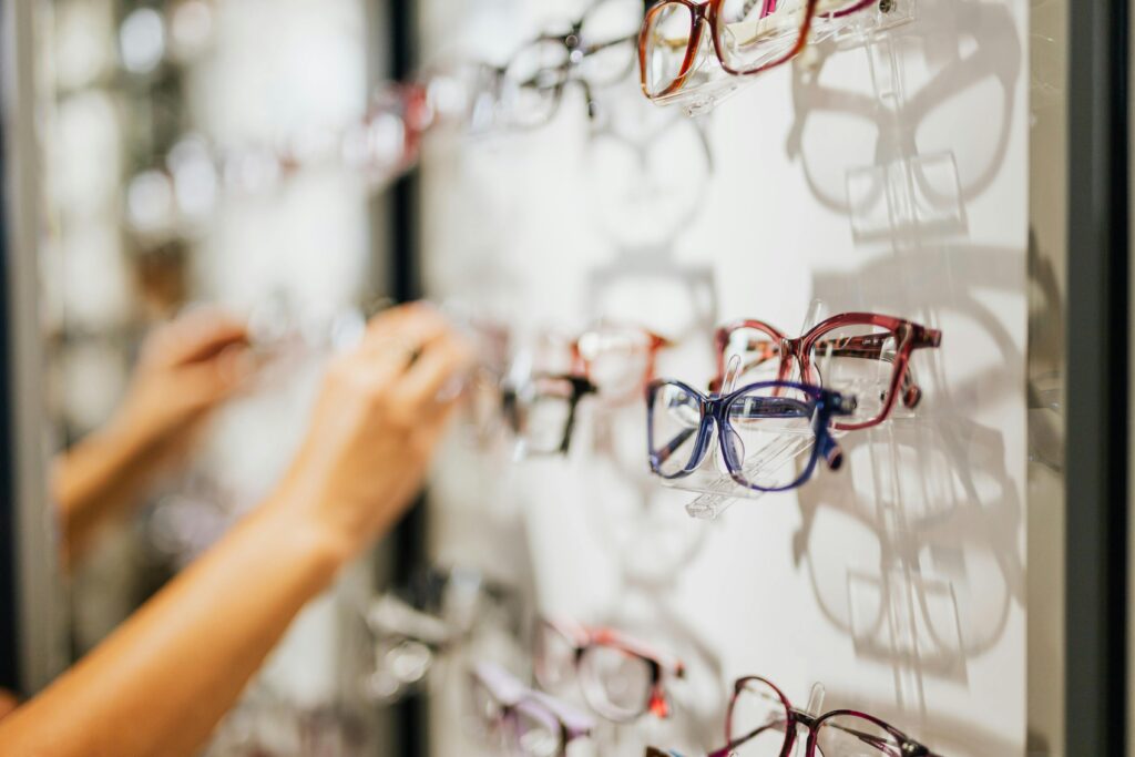 A variety of eyeglasses on display in a modern optical store, showcasing different styles and colors.