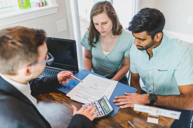 Young couple meeting with real estate agent to discuss property purchase.