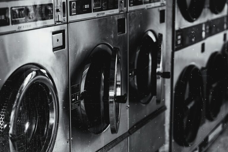 Black and white image of industrial washing machines in a retro style laundry facility.