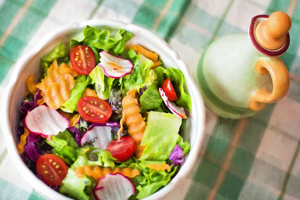 Colorful fresh vegetable salad with cherry tomatoes in a white bowl.