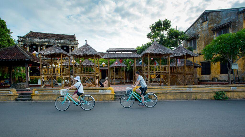 Two cyclists enjoy a leisurely ride in historic Hội An, Vietnam.