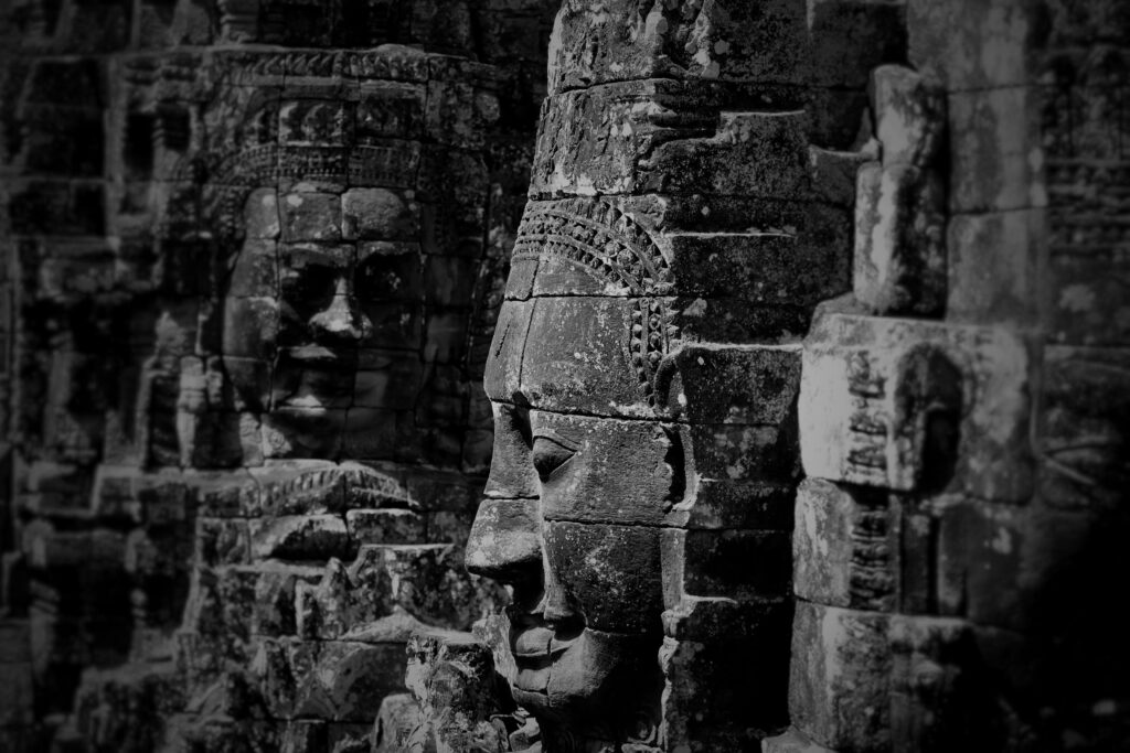 Detailed black and white photo of the Bayon Temple stone faces in Angkor, Cambodia